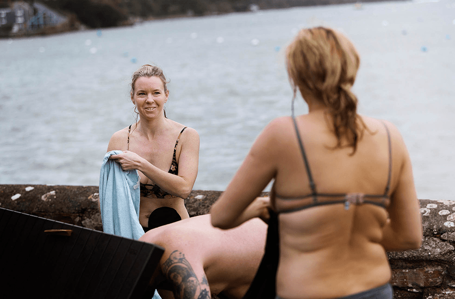 women getting dressed by the sea