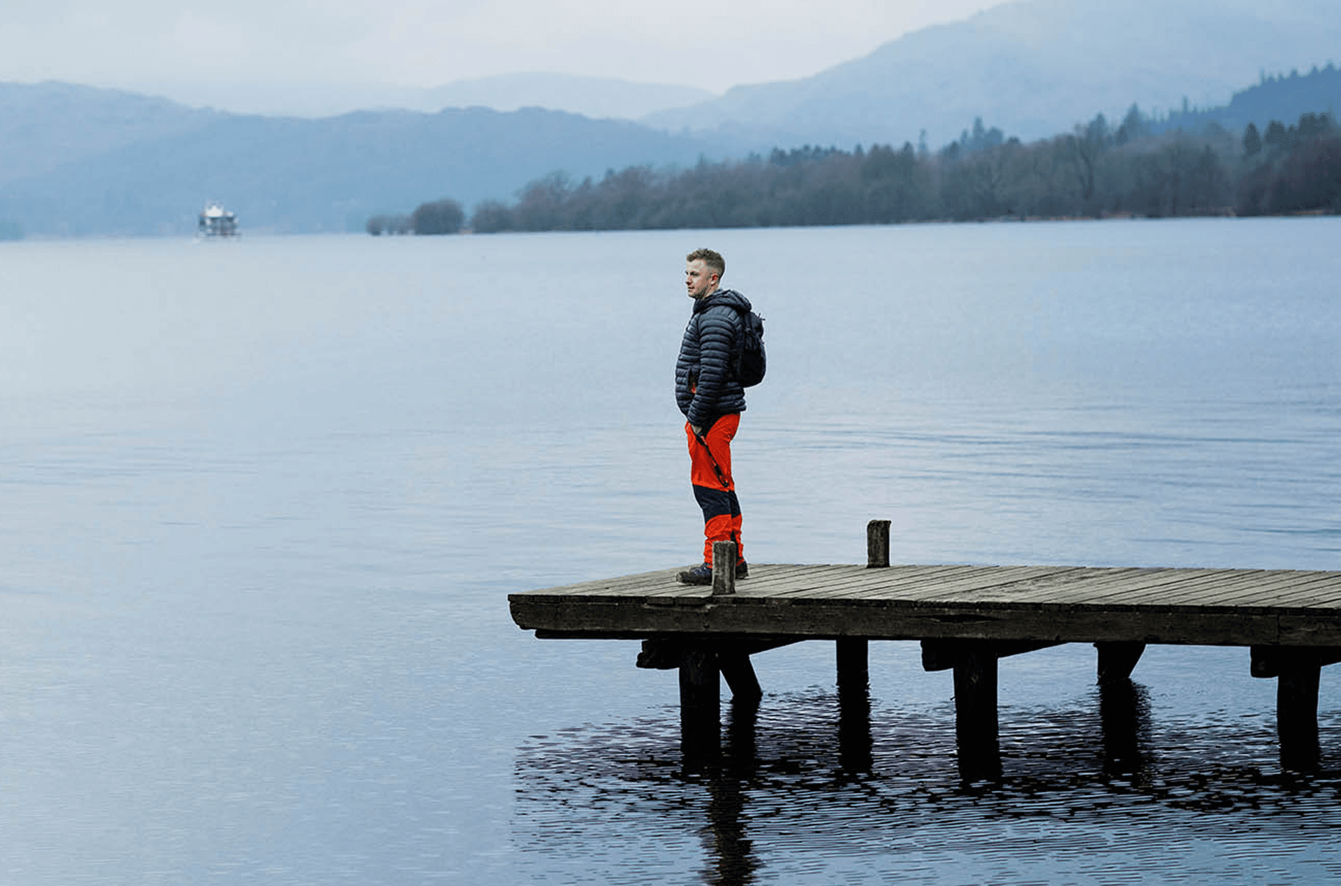 Man standing on a dock by a lake